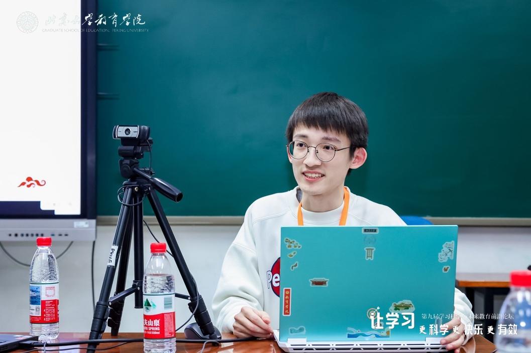 A person sitting at a table with a computer
Description automatically generated